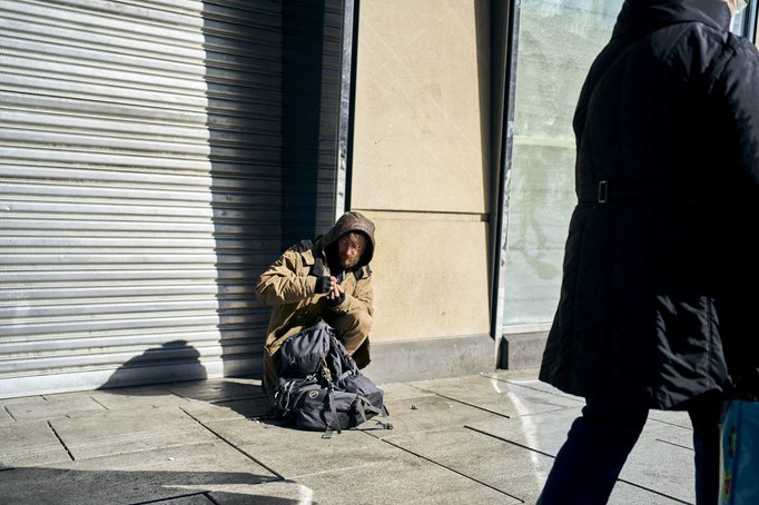 Obdachloser sitzt auf dem Boden