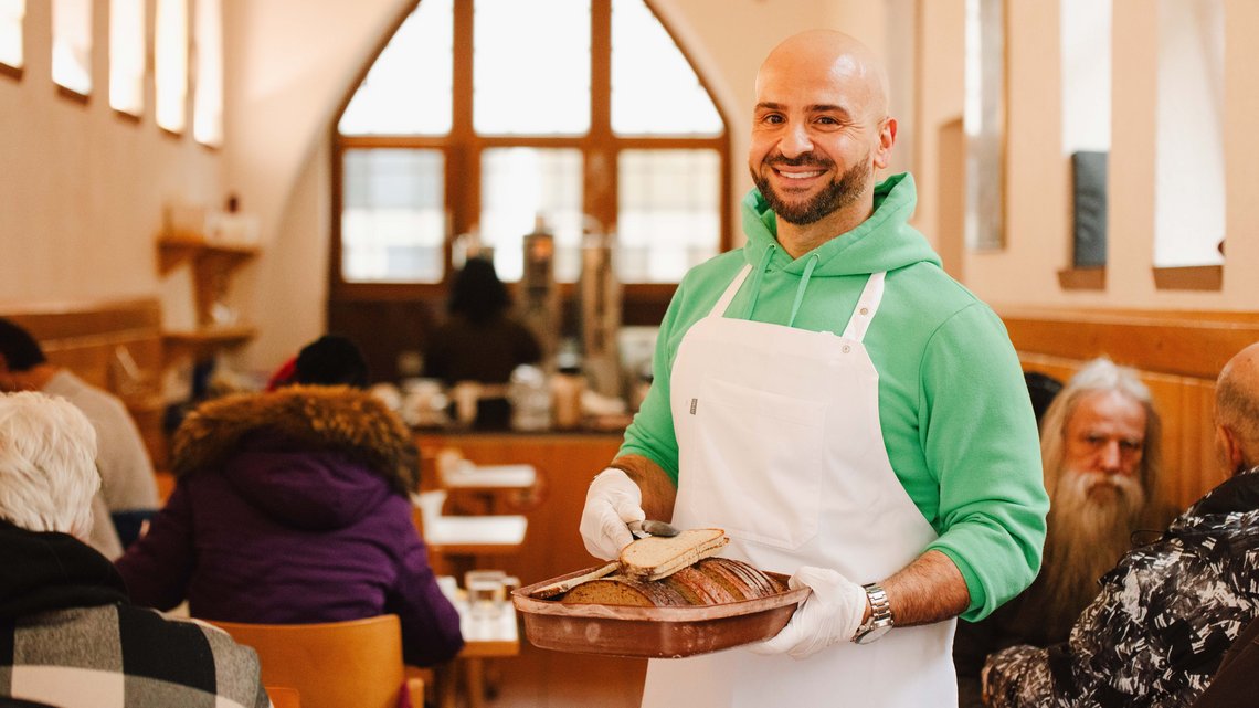Volunteer serves food to the guests